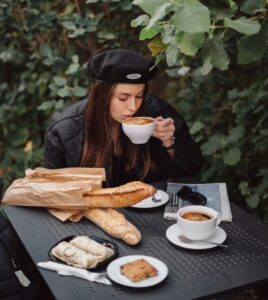 Muitos pães e cafés, uma moça tomando café da manhã