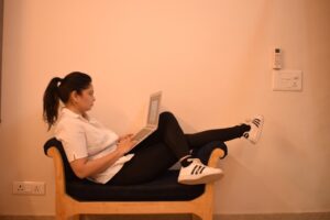 Mulher com notebook sentada na poltrona - sedentarismo