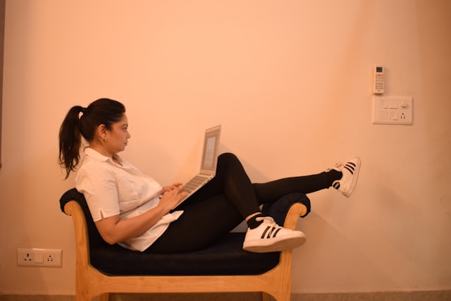 Mulher com notebook sentada na poltrona - sedentarismo