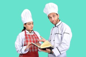 reeducação alimentar, uma cozinheira e um cozinheiro com livro na mão